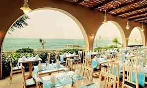 Restaurant med dækkede borde og udsigt til havet gennem buer. (AI-genereret tekst)