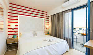 Et hotelværelse med en seng, natbord og åben balkondør. (AI-genereret tekst)