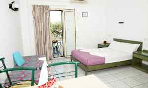 Et hotelværelse med en dobbeltseng, en sofa, et bord med stole og en altan med udsigt. (AI-genereret tekst)