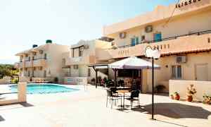 Udendørsområde ved hotel med en pool, parasol og siddepladser. (AI-genereret tekst)