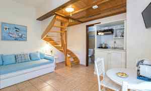 Et rum med træmøbler, en spiraltrappe, en sofa og et bord. (AI-genereret tekst)