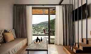 Rum med indretning og udsigt over landskabet gennem en glasdør. (AI-genereret tekst)