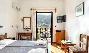 Hotelværelse med to enkeltsenge, spejl, TV og altan med udsigt. (AI-genereret tekst)