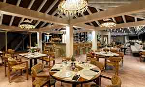 Restaurant med opdækkede borde, stole og bar i baggrunden. (AI-genereret tekst)