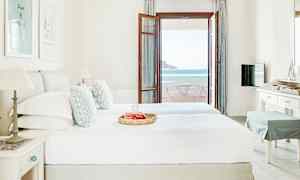 Et hotelværelse med en dobbeltseng, indrettet i lyse farver, og en altandør der fører ud til en balkon med havudsigt. (AI-genereret tekst)