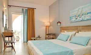 Udsigt over et hotelværelse med en seng, skrivebord og stole, dekoreret med blå og gule farver. (AI-genereret tekst)