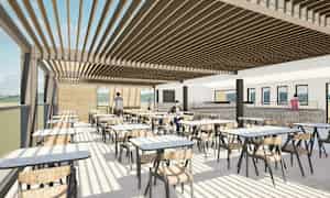 Billedet viser en moderne indendørsrestaurant med store vinduer, borde og stole samt personer, der bevæger sig i forskellige dele af lokalet. (AI-genereret tekst)