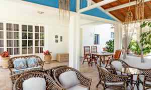 En lys terrasse med siddepladser lavet af rattan og et dekorativt loftsdesign. (AI-genereret tekst)