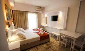 Et hotelværelse med en dobbeltseng, tv og siddeplads. (AI-genereret tekst)