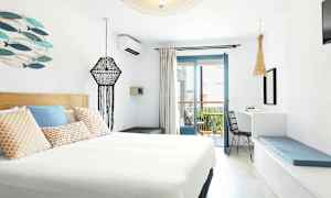 Et moderne indrettet hotelværelse med lys indretning og en altan. (AI-genereret tekst)