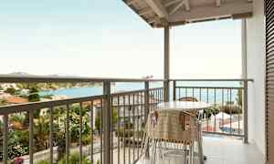 Altan med bord og stole med udsigt over havet. (AI-genereret tekst)