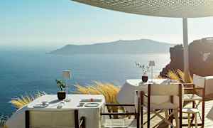 Møblerede borde med hvid dug på en terrasse med fantastisk udsigt over havet og en ø i det fjerne. (AI-genereret tekst)