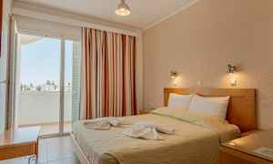 Et soveværelse med en dobbeltseng, dekoreret med håndklæder, og en altan med udsigt. (AI-genereret tekst)