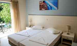 Dobbeltværelse med to enkeltsenge, natbord og altan. (AI-genereret tekst)