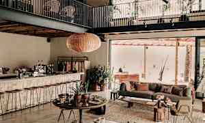 Interiør af en moderne stue med åben planløsning, inkl. siddepladser og grønne planter. (AI-genereret tekst)