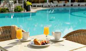 Et bord med morgenmad ved en pool. (AI-genereret tekst)