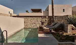 Moderne bygninger, pool og liggestole udendørs. (AI-genereret tekst)