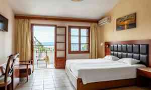 Et hotelværelse med en dobbeltseng, et skrivebord og en altan med udsigt. (AI-genereret tekst)