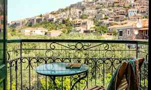 Udsigt fra en altan mod en skråning med huse. (AI-genereret tekst)