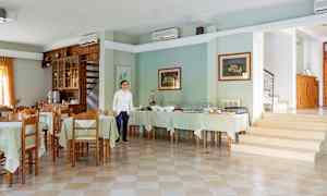 Et rummeligt rum med flere spiseborde og en opstillet buffet. (AI-genereret tekst)