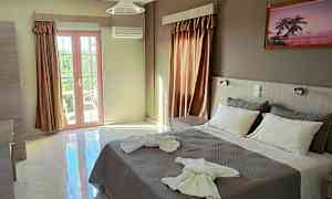 Et hotelværelse med en dobbeltseng dekoreret med håndklæder og store vinduer, der lukker naturligt lys ind. (AI-genereret tekst)