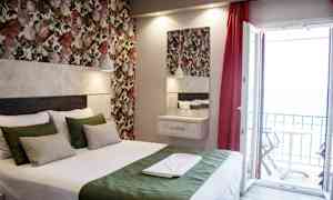 Et værelse med en seng, farverige blomster vægge og en åben altandør. (AI-genereret tekst)