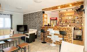 En stue med bar, siddepladser og TV. (AI-genereret tekst)