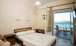 Dobbeltværelse med udsigt over havet gennem en åben altandør. (AI-genereret tekst)