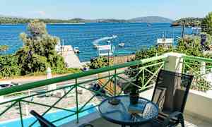 Udsigt fra en balkon over en blå bugt med både og frodige omgivelser. (AI-genereret tekst)