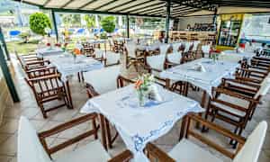 Udendørs restaurantområde med borde og stole samt dekorationer. (AI-genereret tekst)