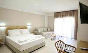 Et hotelværelse med en seng, sofa, skrivebord og stole. (AI-genereret tekst)