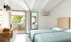 To enkeltsenge i et hotelværelse med adgang til en møbleret balkon. (AI-genereret tekst)