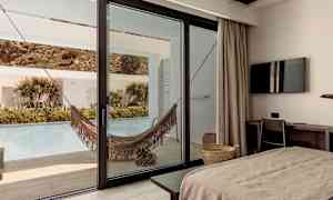 Hotelværelse med udsigt til terrasse med hængekøje og pool. (AI-genereret tekst)