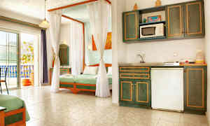 Et lyst hotelværelse med tekøkken og senge indrettet med grønt sengetøj. (AI-genereret tekst)