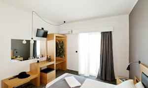 Et hotelværelse med en seng, garderobe og et skrivebord. (AI-genereret tekst)