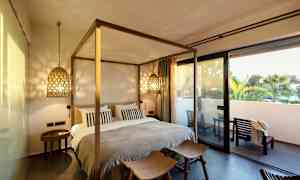 Et soveværelse med seng og hyggelig belysning, samt en terrasse udenfor. (AI-genereret tekst)