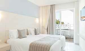 Hotelværelse med to enkeltsenge og altan. (AI-genereret tekst)