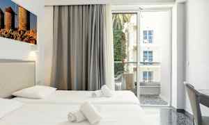Hotelværelse med to enkeltsenge og balkon med udsigt. (AI-genereret tekst)