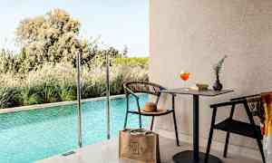 En udendørs pool med en siddegruppe og bord ved siden af. (AI-genereret tekst)