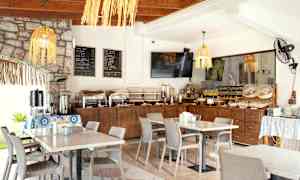 Morgenbuffet i en lys restaurant med dækkede borde. (AI-genereret tekst)