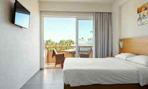 Hotelværelse med dobbeltseng og altan med siddepladser. (AI-genereret tekst)