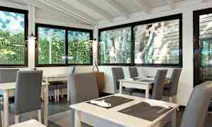 En lys restaurantinteriør med glasvinduer og siddepladser. (AI-genereret tekst)