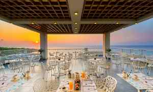 En restaurant med udsigt til havet ved solnedgang. (AI-genereret tekst)