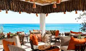 Terrasse med komfortable siddepladser og udsigt over havet. (AI-genereret tekst)