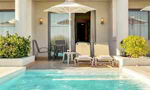 En privat terrasse med liggestole, parasol og en lille pool. (AI-genereret tekst)