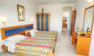 Et hotelværelse med to senge, et skab og en kommode med spejl. (AI-genereret tekst)