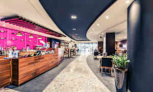 Moderne caféinteriør med træelementer og farverige detaljer. (AI-genereret tekst)