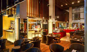 En restaurant med buffet og siddepladser, indrettet med trådekorationer og varm belysning. (AI-genereret tekst)