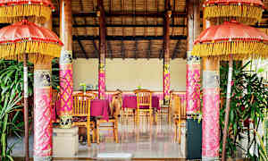 Et indrettet rum med trædetaljer, lyserøde dekorationer og borde med stole. (AI-genereret tekst)