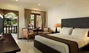 Et hotelværelse med dobbeltseng, siddearrangement og vindue med udsigt til grønne områder. (AI-genereret tekst)